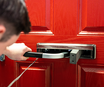 A professional locksmith gaining entry to a house using specialist non-destructive techniques