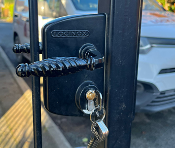 New lock barrel installed on an iron garden gate