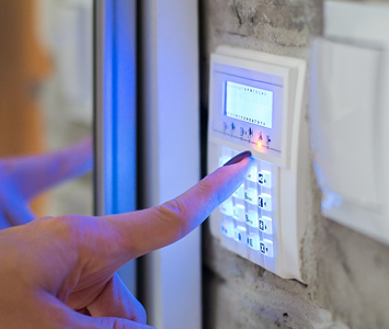 Woman setting wireless alarm at control panel